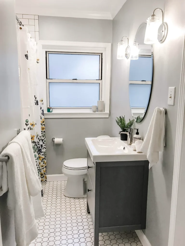 Bright and airy small bathroom with hexagon tile flooring, a modern gray vanity, and a clean minimalist design by Bathroom Renovation Hamilton.